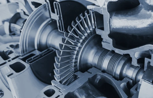 Close-up view of an industrial turbine engine showcasing its intricate metallic components and blades.