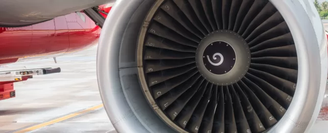 Close-up of a jet engine on an aircraft, showing the turbine blades in detail.