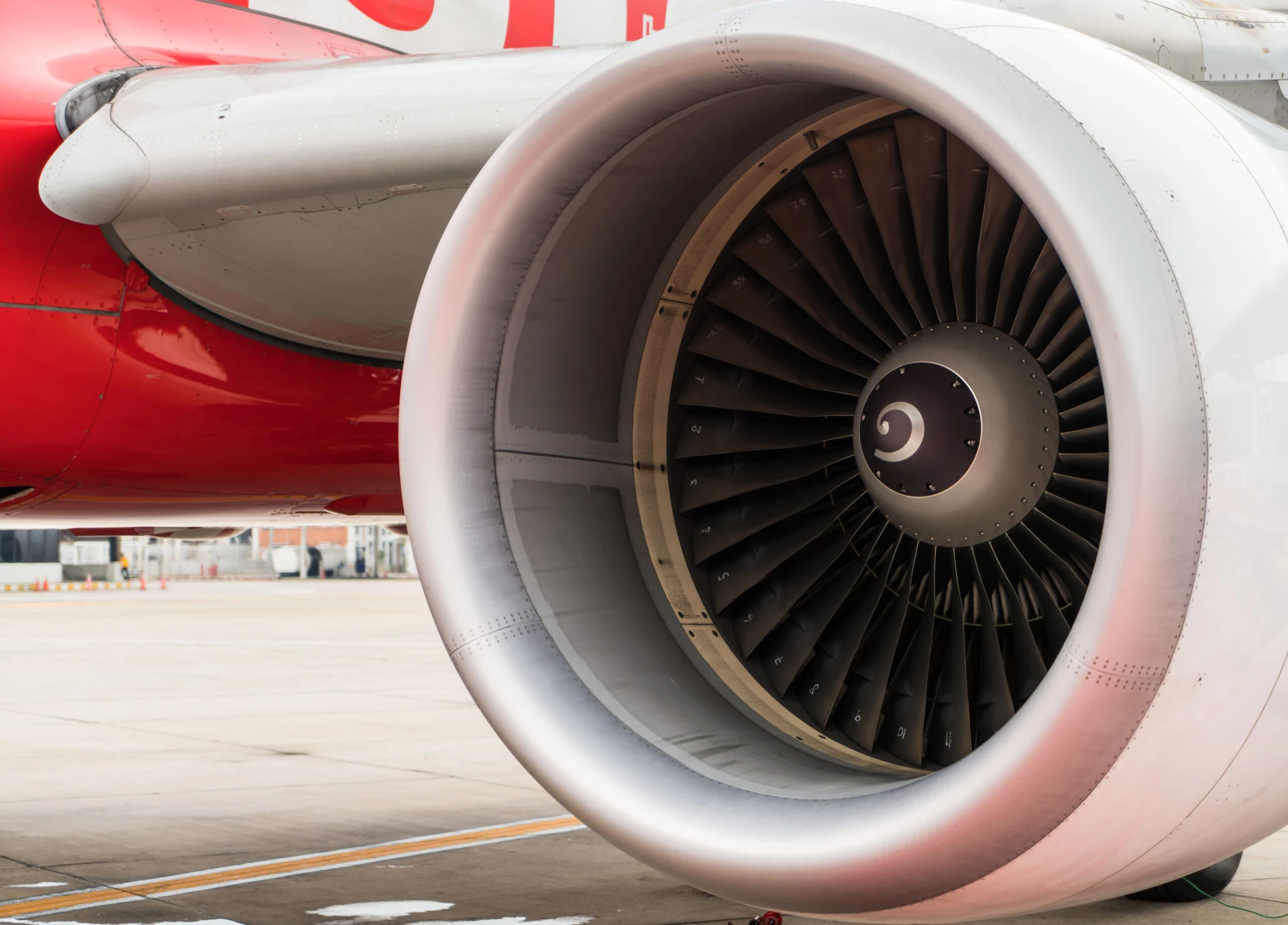 Close-up of an airplane engine turbine on a runway.