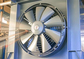 This large industrial metal fan, featuring a sophisticated fan design, boasts multiple blades and is mounted in a square frame, perfectly positioned indoors.