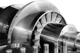 Close-up of a metal turbine blade assembly, showcasing its smooth, curved surfaces and intricate design, a testament to advanced turbomachinery development.
