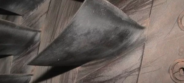 Close-up of industrial turbine blades with visible wear and scratches.