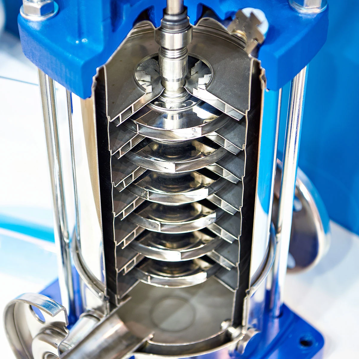 Close-up of an industrial filtration press showcasing an innovative pump design, with visible metal plates stacked vertically inside a blue frame.