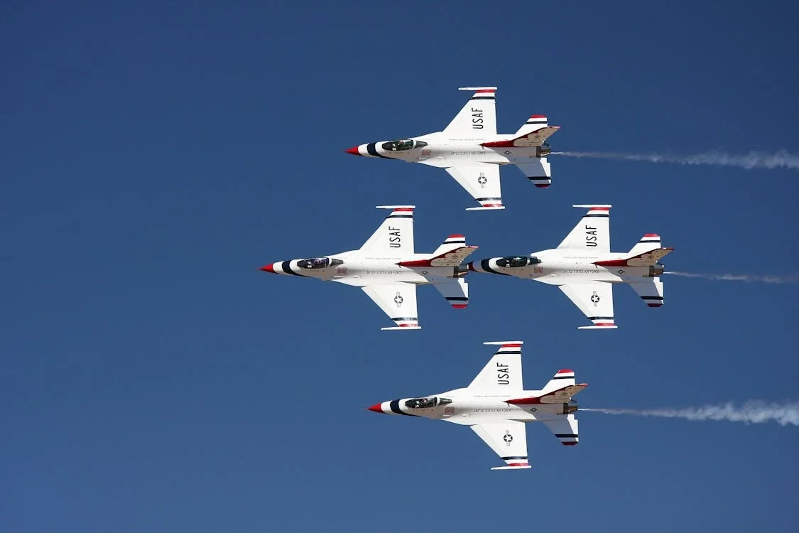 government-research-and-development-6 Four U.S. Air Force Thunderbirds jets, a testament to government development, soar in formation against a clear blue sky.
