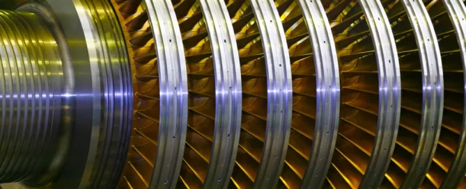Close-up of a large metallic turbine with multiple circular blades and a shiny surface.